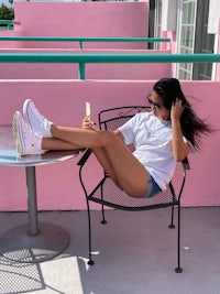 a woman sitting on a chair in a pink building